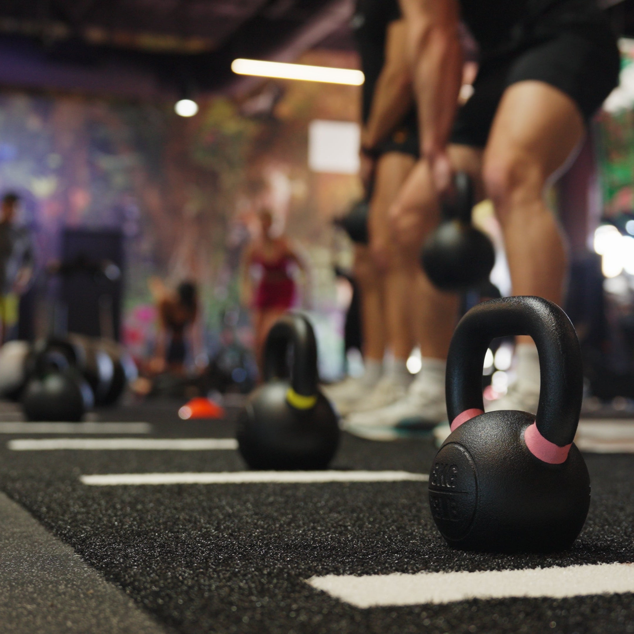 Kettlebells on the turf in the lift section at Hive Fit Club.